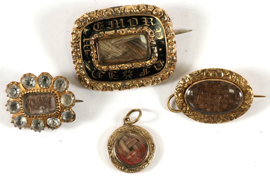 A group of four yellow metal and gold plated mourning brooches.