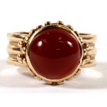 A yellow metal (tests as gold) ring set with a carnelian cabochon, approx UK size 'K'.