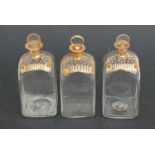 Three 19th century square form decanters with gilt decoration, 17cms (6.75ins) high.