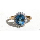 A 9ct gold dress ring with central oval blue stone surrounded by diamonds, approx UK size 'K'.