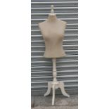 A shop display mannequin on painted tripod stand.