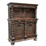 A Flemish dark oak carved buffet sideboard, the architectural raised top with a pair of carved