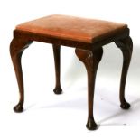 A walnut stool on shell capped cabriole legs and drop in upholstered seat.