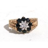 A 9ct gold ring with central diamond surrounded by eight sapphires, approx UK size 'O'.