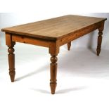 A stripped pine country farmhouse kitchen table on turned legs, 211 by 84cms (83 by 33ins).