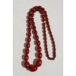 A string of cherry amber Bakelite beads, the largest bead 33mms, total weight 89g.