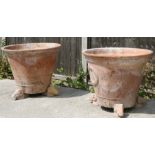A large pair of terracotta plant pots standing on three rams head feet, 81cms (32ins) diameter.