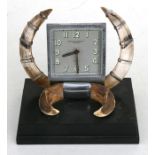 A Goldsmith's & Silversmith's Art Deco 8-day desk clock with white metal mounted boars tusks on a
