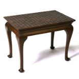 A walnut occasional table, the rectangular top carved to simulate latticed leather, on cabriole legs