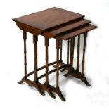 A reproduction crossbanded mahogany nest of tables on turned supports, the largest 49cms (19ins)