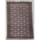 A Persian Torkoman woollen handmade rug with repeat design on a fawn ground, 144 by 98cms (56.5 by