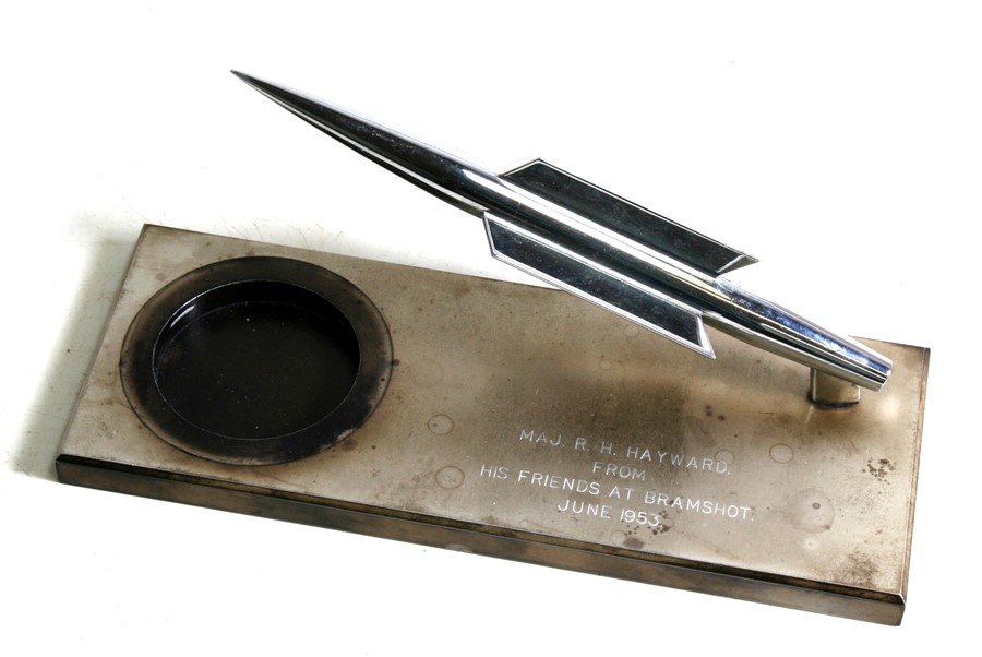 A chrome plated four fin guided missile desk top ornament mounted on a metal base (possibly