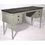 A distressed painted four-drawer desk, 140cms (55ins) wide.