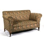 An Edwardian upholstered two-seater drop-arm sofa on square tapering front supports, 146cms (57.