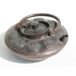 A Tibetan copper teapot decorated with roundels, 18cms (7ins) diameter.