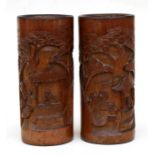 A pair of Chinese bamboo brush pots carved with figural scenes, 22cms (8.25ins) high.