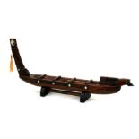 A carved wooden model of a Maori war canoe, 55cms (21.75ins) long.