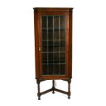 An oak corner display case with leaded glass door, on barleytwist supports, 69cms (27ins) wide;
