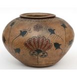 A North African terracotta pot decorated with flowers, 23cms (9ins) high.