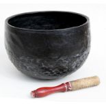 A Tibetan bronze Buddhists singing bowl with mallet, 31cms (12.25ins) diameter (a/f).