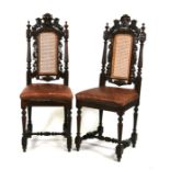 A pair of Victorian oak chairs with carved lion crest rails, caned backs and upholstered seats.
