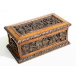 A 19th century carved oak tea caddy with grape and vine leaf decoration, the interior with a pair of