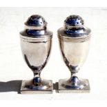 A pair of Georgian silver pepper pots, London 1793 and London 1799, 7cms (2.75ins) high (2).