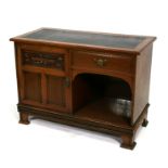 An Art Nouveau walnut side cabinet/desk with inset leather top, with single drawer and cupboard