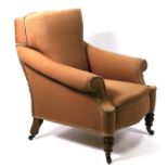 A Victorian upholstered armchair on turned front supports.