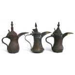 A group of three Turkish / Islamic brass dallah coffee pots, the largest 30cms (12ins) high (3).