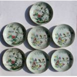 Seven Chinese shallow dishes decorated with birds perched amongst flowering foliage and calligraphy,