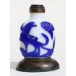 A Chinese cameo glass snuff bottle decorated with birds and flowers, mounted on a bronze stand, 9cms