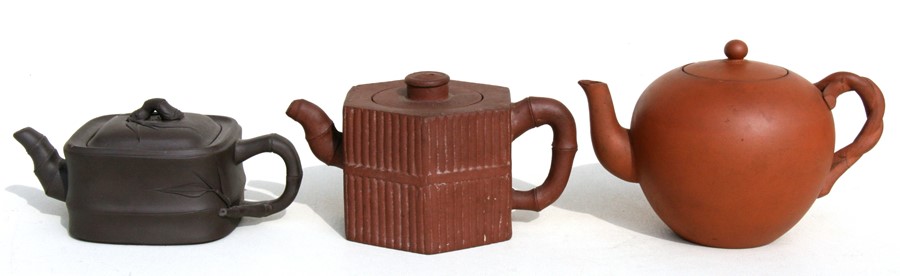 A group of three Chinese Yixing pottery teapots, the largest 18cms (7.2ins) wide.Condition Report