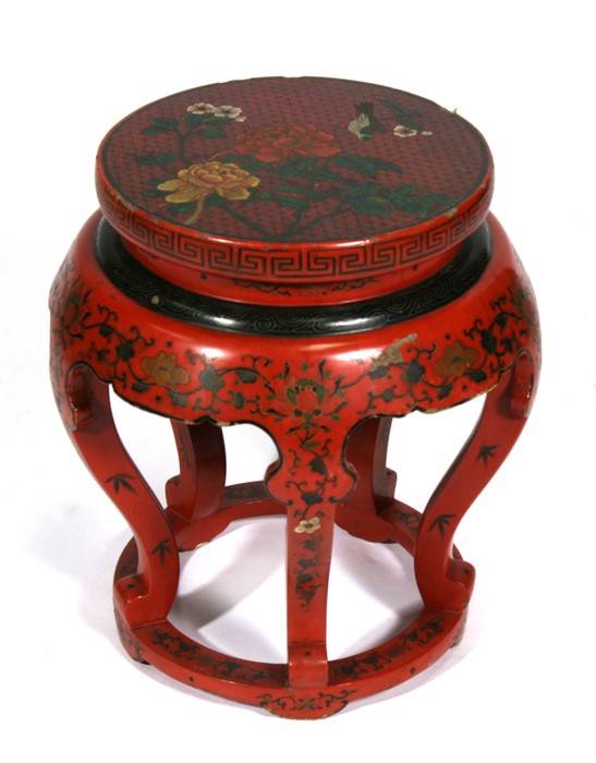 A Chinese lacquer stand decorated with flowers and scrolling foliage on a red ground, 48cms (