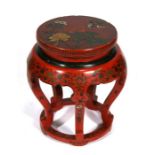 A Chinese lacquer stand decorated with flowers and scrolling foliage on a red ground, 48cms (