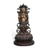 A Chinese glazed and gilded Buddhist deity figure on a hardwood lotus stand, 28cms (11ins) high.