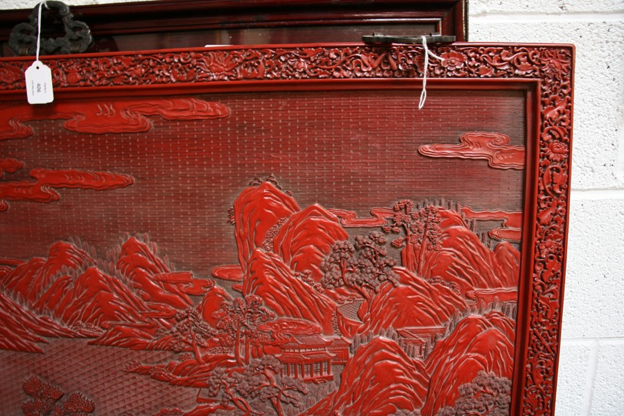 A large Chinese carved red cinnabar panel depicting a mountainous river scene within a foliate - Image 4 of 13