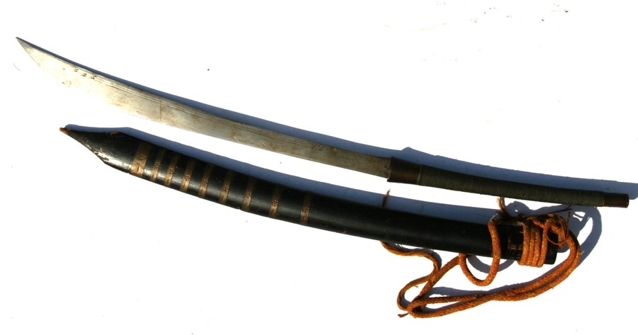 A 19th century Burmese Dha sword in its wood and brass scabbard. Blade length 48cms (19ins)