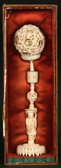 An early 20th century Chinese ivory puzzle ball on figural stand, the ball highly carved with