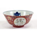 A Chinese famille rose bowl decorated with precious objects within roundels on a pink sgraffito