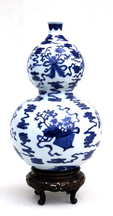 A Chinese blue & white double gourd vase decorated with flowers and precious objects, blue seal mark