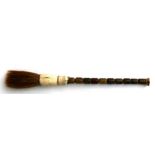 A Chinese calligraphy brush with bone and jade handle, 26cms (10.25ins) long.