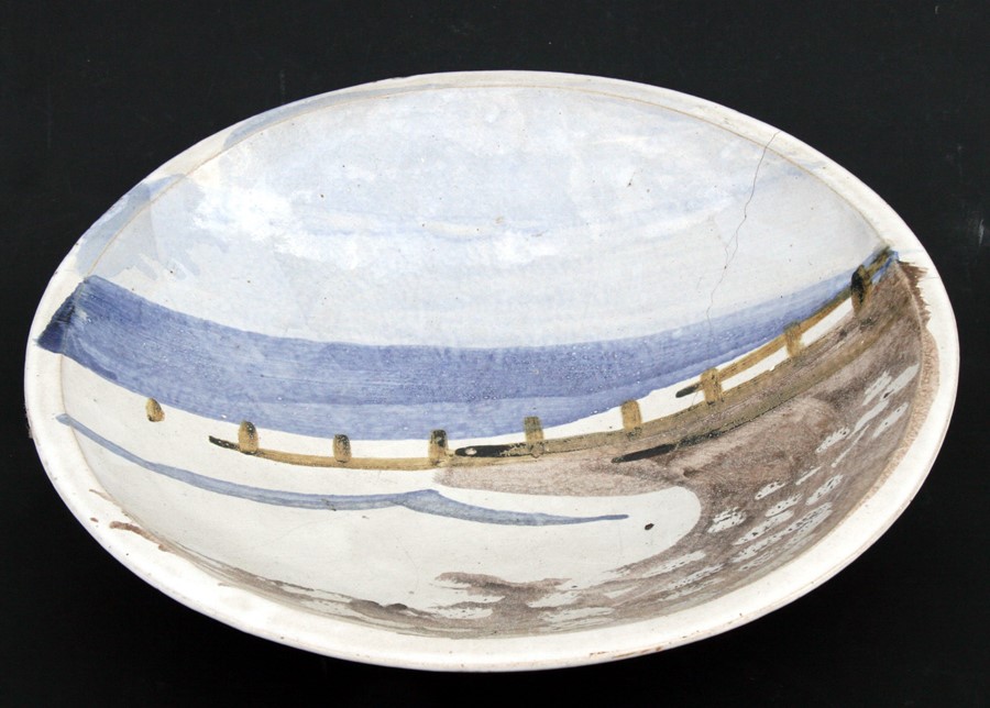 A Michael Woods Studio Pottery shallow bowl decorated with a beach scene, 41cms (16cms) (a/f).