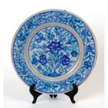 A Persian / Iznik plate decorated with flowers and foliage, 26cms (10ins) diameter.