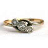 An 18ct gold three stone diamond crossover ring, approx UK size 'N'.