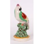 A Staffordshire figure in the form of a parrot perched on a tree stump, 23cms (9ins) high.