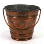 A Persian copper bucket decorated with figures and animals, 23cms (8ins) diameter.