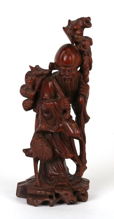 A Chinese hardwood figure in the form of Shoulau, 25cms (9.75ins) high.