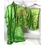 A pair of Chinese silk embroidered pyjamas and gown, decorated with a dragon on a lime green