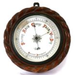 A Victorian wall mounted aneroid barometer in a carved rope twist case, 24cms (9.5ins) diameter.